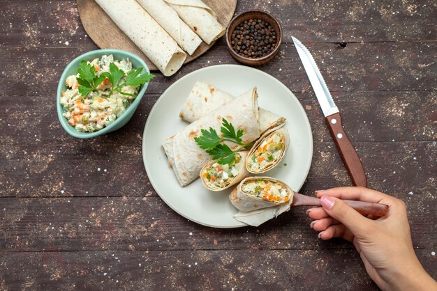 Draufsicht Lavash Sandwich Brötchen mit Salat und Fleisch in Scheiben geschnitten zusammen mit Salat auf dem Holz Schreibtisch Snack Food Mahlzeit Sandwich geschnitten