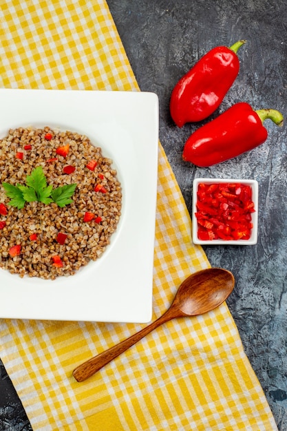 Draufsicht lecker gekochter Buchweizen-Innenteller mit Paprika auf hellgrauem Tisch