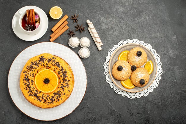 Draufsicht lecker süßer Kuchen mit Keksen und Tasse Tee auf grauer Oberfläche süßer Kuchen Kuchen Dessert Keks Tee