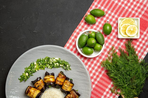 Draufsicht leckere Auberginenröllchen gekochtes Essen mit Reis und Feijoa auf dunkler Oberfläche kochendes Essen in grüner Farbe