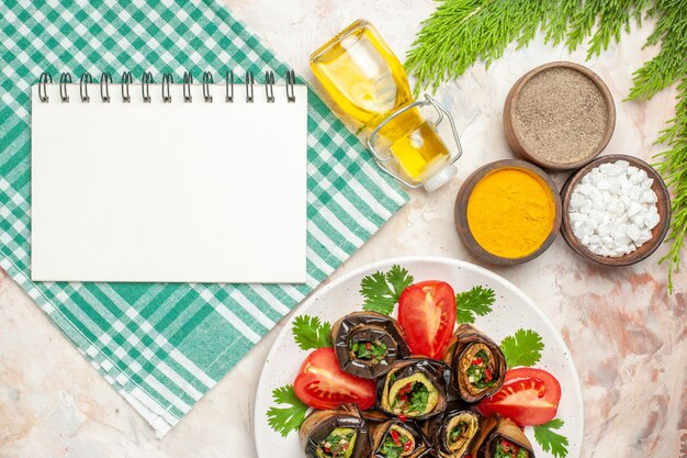 Draufsicht leckere Auberginenröllchen mit Gewürzen Tomaten und Gemüse