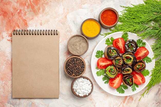 Draufsicht leckere Auberginenröllchen mit grünen Tomaten und Gewürzen