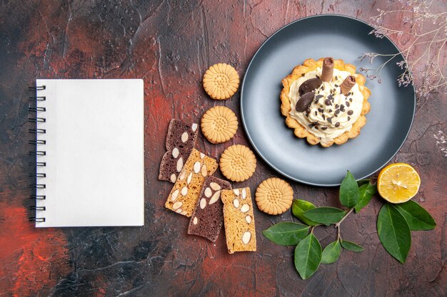 Draufsicht leckere cremige Kuchen mit Keksen auf dunklem Boden süßer Kuchen Dessert