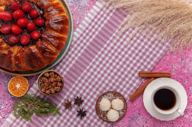 Draufsicht leckere Erdbeerkuchen mit Tasse Tee auf dem hellrosa