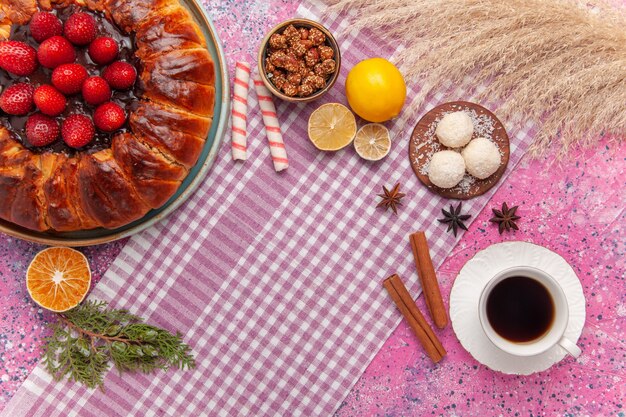 Draufsicht leckere Erdbeerkuchen mit Tasse Tee auf dem Rosa