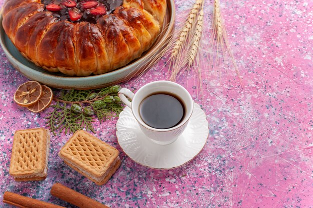 Draufsicht leckere Erdbeerkuchen mit Tasse Tee und Waffeln auf rosa