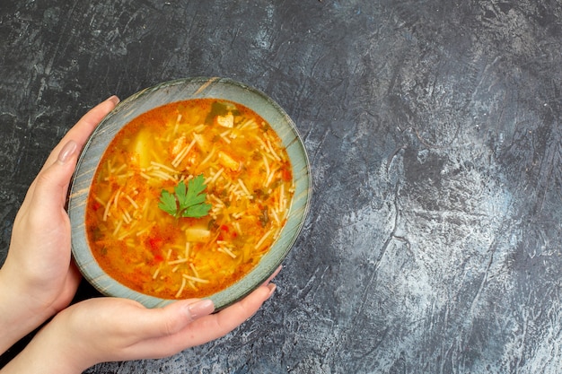 Draufsicht leckere Fadennudelnsuppe im Teller auf dem hellgrauen Tisch