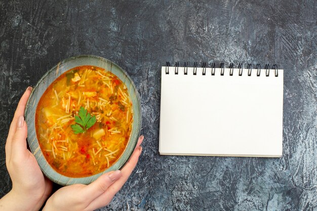 Draufsicht leckere Fadennudelnsuppe im Teller auf dem hellgrauen Tisch