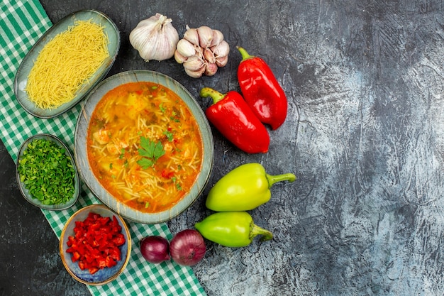 Draufsicht leckere Fadennudelnsuppe mit Knoblauch und Gemüse auf dem hellgrauen Tisch