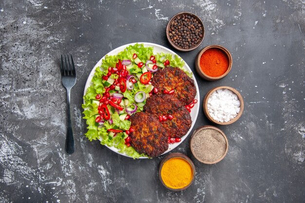 Draufsicht leckere Fleischkoteletts mit frischem Salat auf dem grauen Hintergrundfoto Food Dish Fleisch