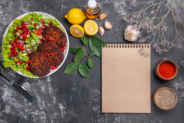 Draufsicht leckere Fleischkoteletts mit Gemüsesalat auf grauem Hintergrundgericht Foto-Lebensmittelmahlzeit