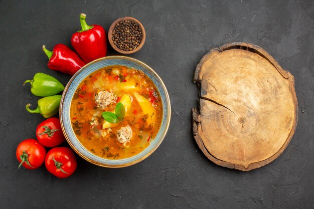 Draufsicht leckere Fleischsuppe mit frischem Gemüse auf der dunklen Tischfotogeschirr-Lebensmittelfarbe