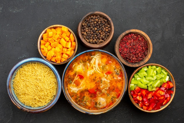 Draufsicht leckere Fleischsuppe mit Gemüse und Gewürzen auf dem grauen Hintergrund Salatsuppe Mahlzeit Essen Abendessen