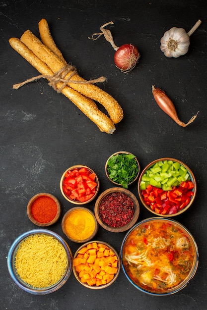 Kostenloses Foto draufsicht leckere fleischsuppe mit gemüse und gewürzen auf grauem schreibtisch salatsuppe mahlzeit essen abendessen