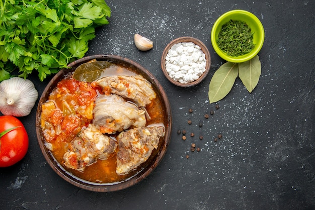 Draufsicht leckere Fleischsuppe mit Grüns auf einer dunklen Fleischfarbe graue Soße Mahlzeit warmes Essen Kartoffel Foto Abendessen Gericht