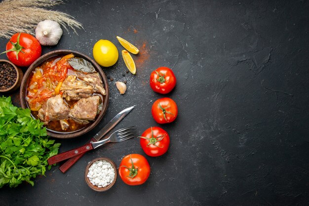 Draufsicht leckere Fleischsuppe mit Tomaten und Grüns auf dunkler Soße Mahlzeit Gericht warmes Essen Fleisch Kartoffel Farbfoto Abendessen Küche