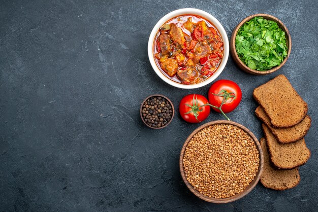 Draufsicht leckere Gemüsesuppe mit Brot und Gemüse auf einem dunkelgrauen