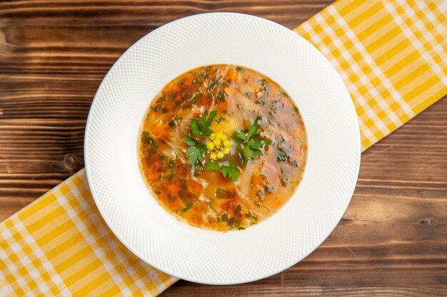 Draufsicht leckere Gemüsesuppe mit Gemüse auf brauner Holztischsuppe Lebensmittelgemüsegewürze