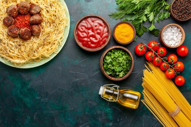 Draufsicht leckere italienische Nudeln mit Fleischbällchen und verschiedenen Gewürzen auf blauem Hintergrund