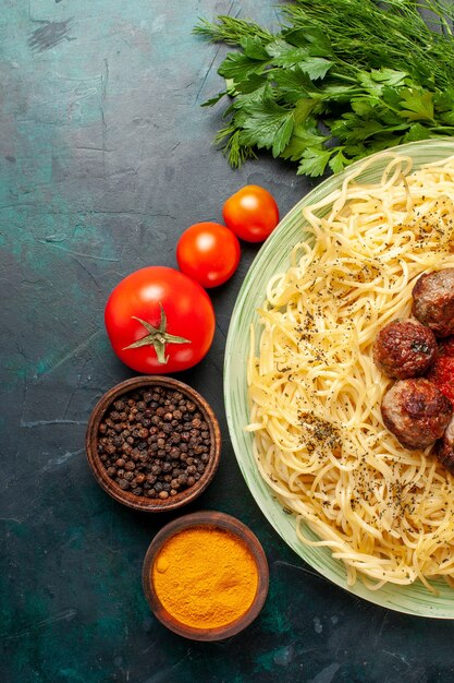 Draufsicht leckere italienische nudeln mit fleischbällchen und verschiedenen gewürzen auf dem dunkelblauen hintergrund