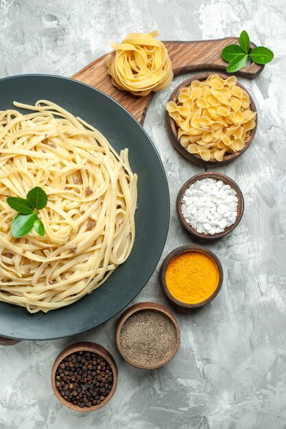 Draufsicht leckere italienische Pasta mit Gewürzen auf hellem Hintergrund