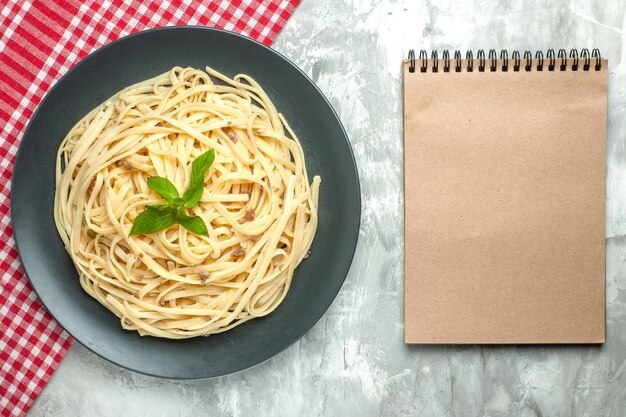 Draufsicht leckere italienische Pasta mit Notizblock auf weißem Hintergrund