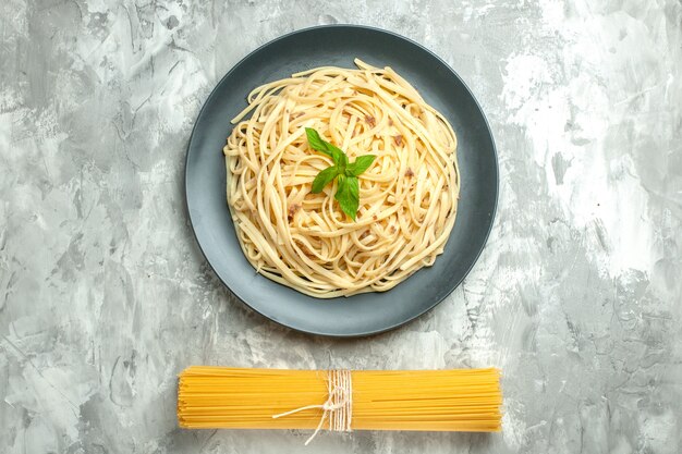 Draufsicht leckere italienische Pasta mit roher Pasta auf weißem Hintergrund