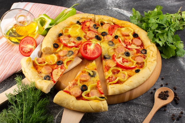 Draufsicht leckere käsige Pizza mit roten Tomaten, schwarzen Oliven, Gemüse und Würstchen auf dem dunklen Schreibtisch Fast-Food-italienischer Teigauflauf