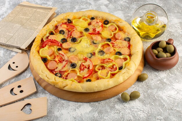 Draufsicht leckere käsige Pizza mit schwarzen Olivenwürsten und roten Tomaten zusammen mit Öl und Oliven auf dem grauen Hintergrund Fast-Food-italienisches Teigmehl backen