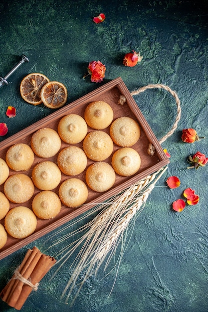 Kostenloses Foto draufsicht leckere kekse in holzkiste auf dunkelblauem hintergrund zuckerkeks-keks-torten farbe süßer nuss-teekuchen