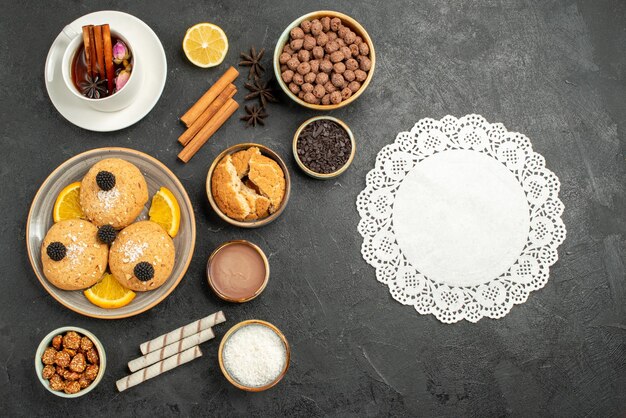 Draufsicht leckere Kekse mit Tasse Tee auf dunkler Oberfläche Kuchen Kuchen Zucker Dessert Kekse Kekse