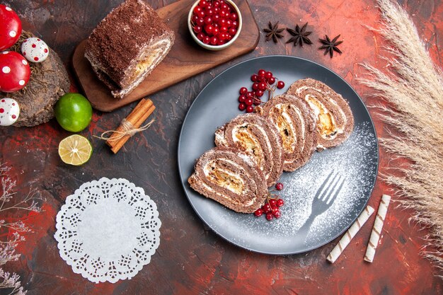 Draufsicht leckere Keksrollen mit Früchten auf dunklem Hintergrund