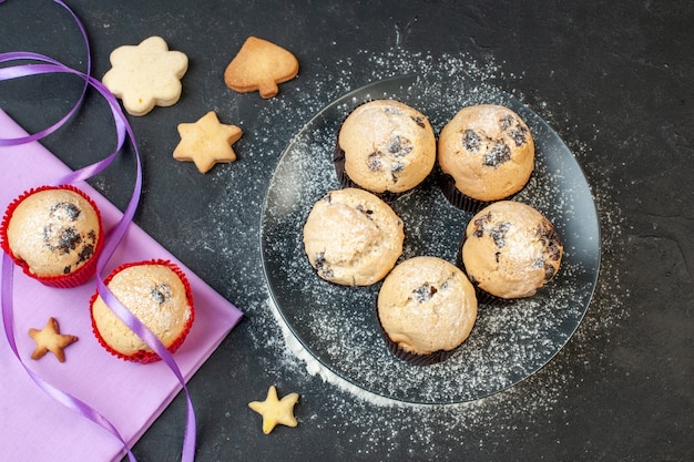 Kostenloses Foto draufsicht leckere kleine kuchen mit schokolade auf dunklem hintergrund