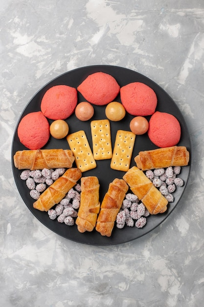 Kostenloses Foto draufsicht leckere kuchen mit bagels und süßigkeiten auf weißem schreibtisch