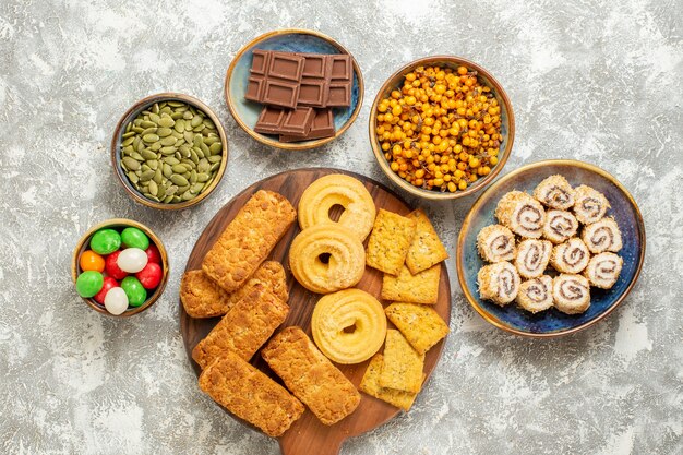 Draufsicht leckere Kuchen mit Bonbons und Keksen auf weißem Hintergrund