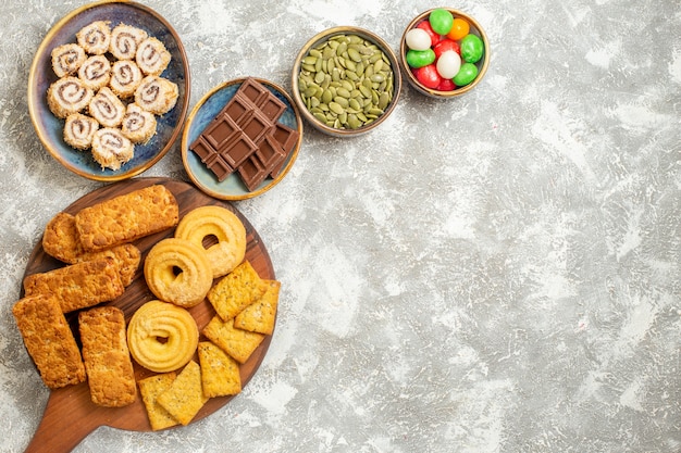 Draufsicht leckere Kuchen mit Bonbons und Keksen auf weißem Hintergrund