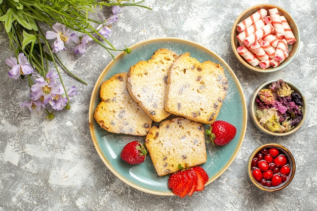 Draufsicht leckere Kuchenscheiben mit Erdbeeren auf Licht