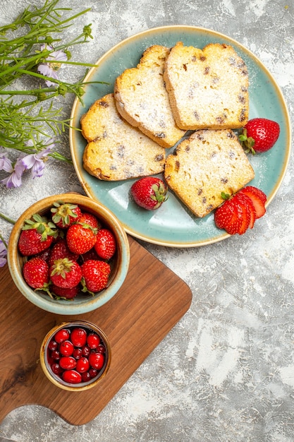 Draufsicht leckere Kuchenscheiben mit Erdbeeren auf Licht