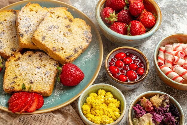 Draufsicht leckere Kuchenscheiben mit frischen Erdbeeren auf Licht