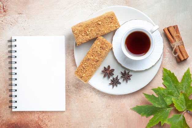 Draufsicht leckere Kuchenscheiben mit Tasse Tee auf Licht