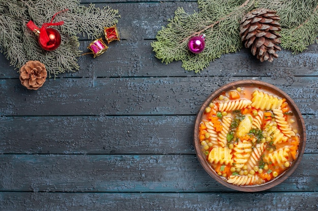 Draufsicht leckere Nudelsuppe aus spiralförmiger italienischer Pasta mit Grüns auf dem dunkelblauen Schreibtisch Küche Nudelsuppe Farbgericht Abendessen