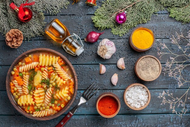 Draufsicht leckere Nudelsuppe aus spiralförmiger italienischer Pasta mit Grüns auf dunkelblauem Boden Küche Nudelsuppe Abendessen Farbgericht