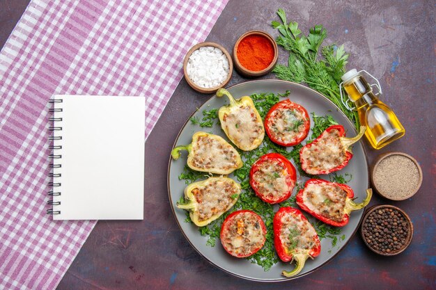 Draufsicht leckere Paprika köstliche gekochte Mahlzeit mit Fleisch und Grüns auf der dunklen Oberfläche Abendessen Mahlzeit Gericht Pfeffer würziges Essen