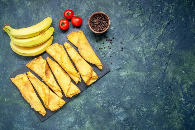 Draufsicht leckere Pfannkuchen mit Bananen auf dunklem Hintergrund Kuchenteig Hotcake Farbe Mahlzeit Gebäck süßes Kuchenfleisch