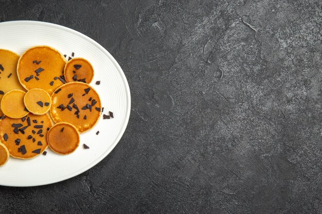 Draufsicht leckere Pfannkuchen mit Choco-Chips auf dunklem Schreibtisch