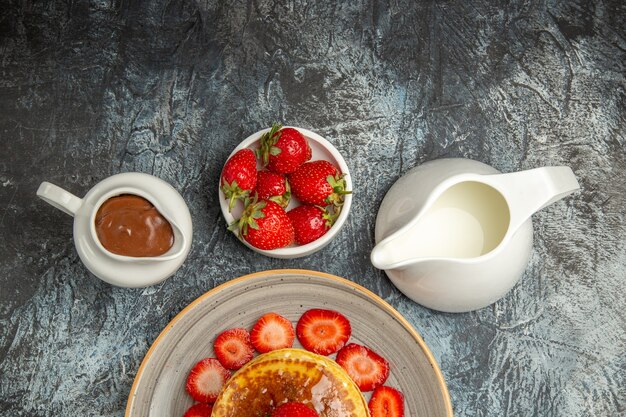 Draufsicht leckere Pfannkuchen mit Erdbeeren und Honig auf dem Licht