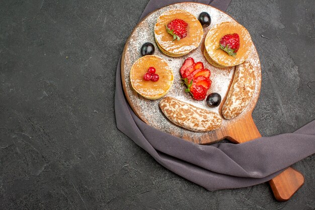 Draufsicht leckere Pfannkuchen mit Früchten und süßen Kuchen im Dunkeln