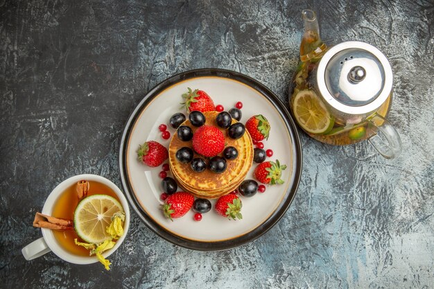 Draufsicht leckere Pfannkuchen mit Früchten und Tee auf Licht