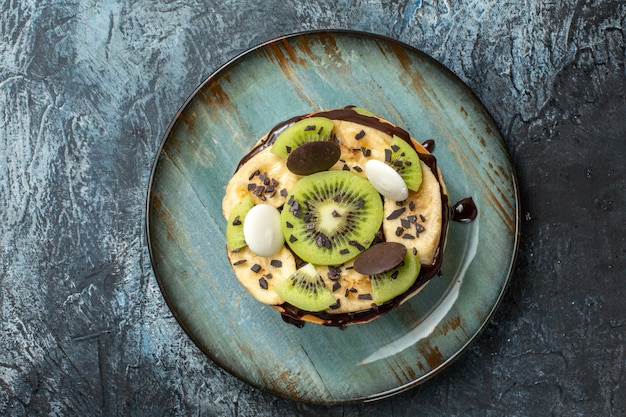 Draufsicht leckere Pfannkuchen mit geschnittenen Früchten und Schokolade auf dunkler Oberflächenfarbe Kuchen Frühstück Zucker Frucht süßes Dessert