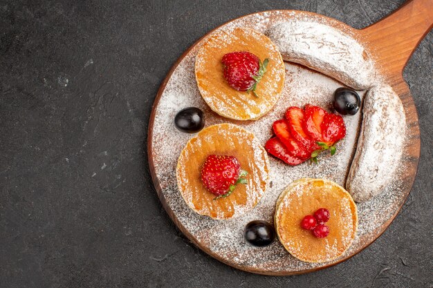 Draufsicht leckere Pfannkuchen mit Obst und Kuchen im Dunkeln